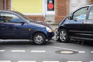 Two cars suffer damages from a head-on collision in the street