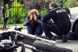 woman comforted by police after motorcycle crash