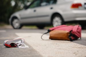 backpack and sneaker on street after car crash